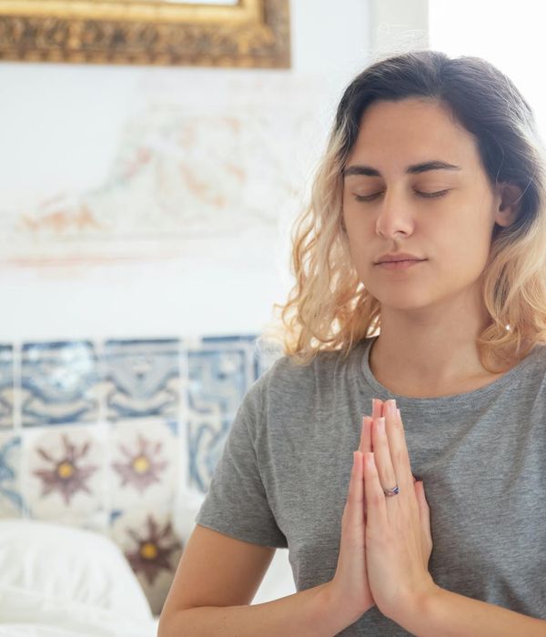 A calm woman with closed eyes in a serene meditative state.